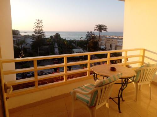 a balcony with a table and chairs and a view of the ocean at Salvatore Room With Breakfast- Garden View in Alexandria