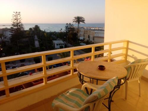 una mesa y sillas en un balcón con vistas en Salvatore Room With Breakfast- Garden View en Alexandría