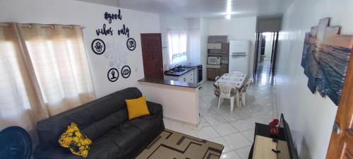 sala de estar con sofá y cocina en Casa inteira ITANHAÉM Piscina AQUECIDA, Churrasqueira e Wi-fi, en São Paulo