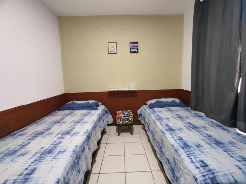 a room with two beds and a table at Flat Smart Home in São Luís