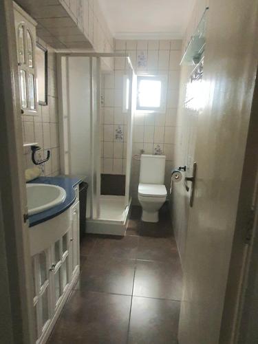 a bathroom with a white toilet and a sink at Amplio Apartamento Playa Puerto de Sagunto in Puerto de Sagunto