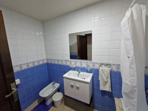 a blue and white bathroom with a toilet and a sink at Appartement Saidia avec piscine in Saïdia