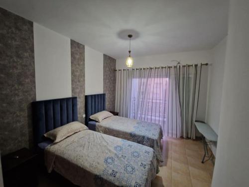 a hotel room with two beds and a window at Appartement Saidia avec piscine in Saïdia
