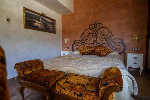 a bedroom with a large bed and a chair at Es Cloper in Cadaqués