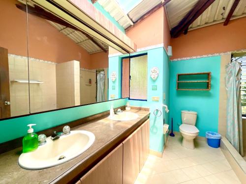 La salle de bains est pourvue de 2 lavabos et de toilettes. dans l'établissement Hermosa Casa FINCA Piscina Voleibol WiFi Villeta, à Tobia