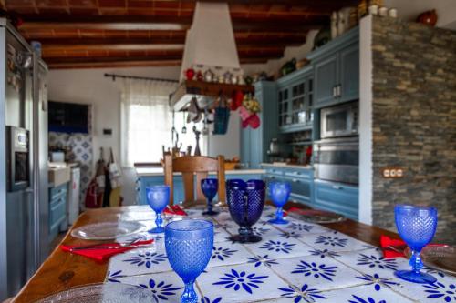 a kitchen with a table with blue glasses on it at Es Cloper in Cadaqués