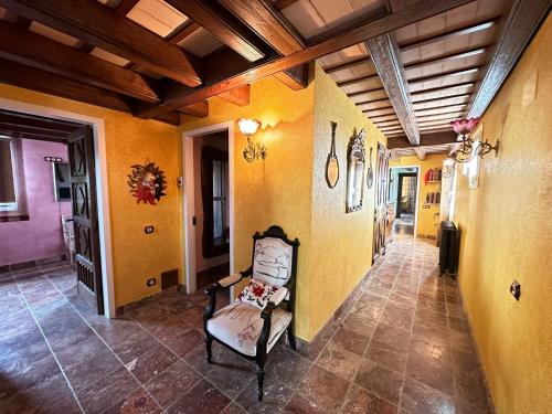 a hallway with a chair in a room with yellow walls at Es Cloper in Cadaqués