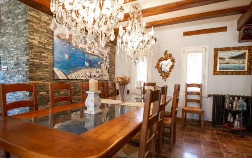 a dining room with a wooden table and a chandelier at Es Cloper in Cadaqués
