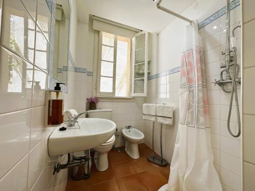 ein weißes Bad mit einem Waschbecken und einem WC in der Unterkunft Estrela Charming Rooms by HOST-POINT in Lissabon