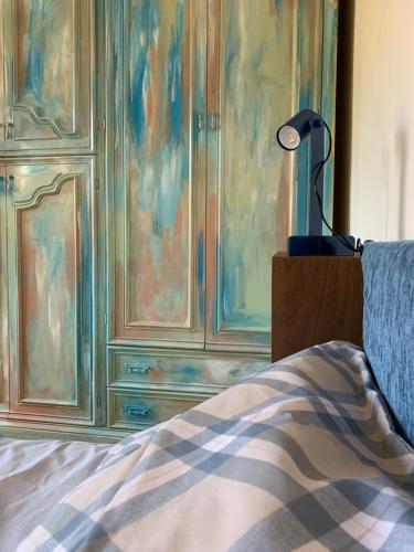 a bedroom with a dresser and a lamp next to a bed at Well in Filettole