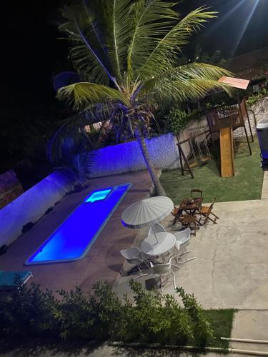 uma piscina à noite com uma piscina azul em Flats Villa Gelú em Barra Grande