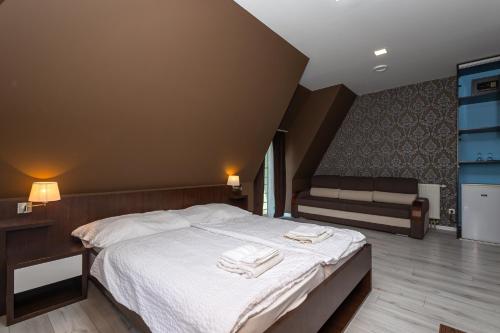 een slaapkamer met een bed met twee handdoeken erop bij Penzion Velky Meder in Dunajská Streda