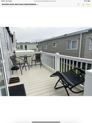 a balcony with chairs and a table on a deck at Carvan E102 in Steeple
