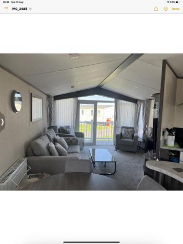 Steeple的住宿－Carvan E102，客厅配有沙发和桌子