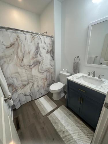 een badkamer met een marmeren douchegordijn en een toilet bij NEW 3 bedroom - Thoroughbred Farm & Lake Views! in Saratoga Springs