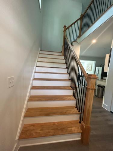 a staircase in a home with wood and white walls at NEW 3 bedroom - Thoroughbred Farm & Lake Views! in Saratoga Springs