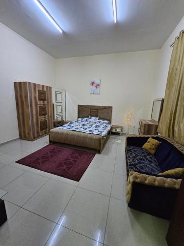 a bedroom with two beds and a couch in it at استوديو مفروس in As Sād