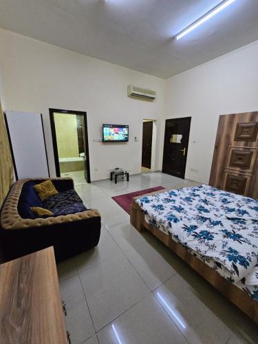 1 dormitorio con cama y sofá en استوديو مفروس, en As Sād