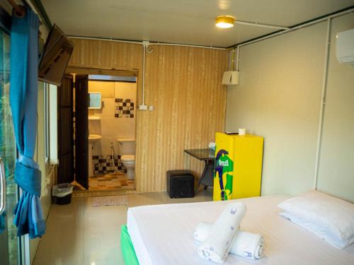 Habitación con cama y nevera amarilla. en Beach Box Resort at Rimlay Rayong en Rayong