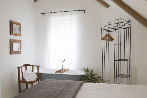 een slaapkamer met een bed en een bad naast een raam bij Kogman & Keisie Guest Farm in Montagu