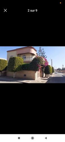 l’immagine di un edificio con cespugli e fiori di Villa Sousse ad Agadir