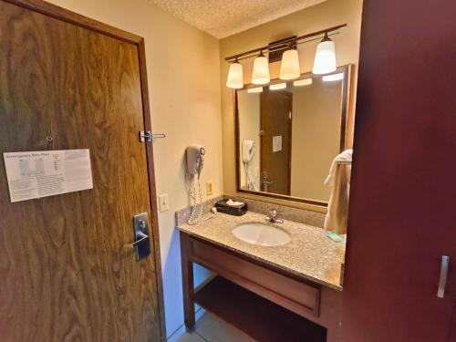 a bathroom with a sink and a mirror at Roosevelt Hotel in Williston