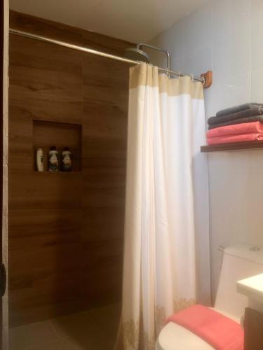 a bathroom with a shower with a white shower curtain at Vigan Living in Vigan