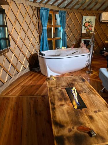 a man in a bath tub in a yurt at Glamping montain experience in São Joaquim