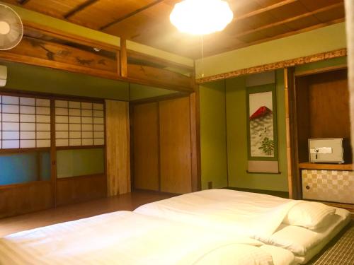 1 dormitorio con 1 cama blanca en una habitación en NOW TRAVEL ShinOsaka, en Osaka