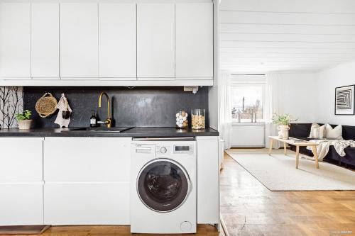 a white kitchen with a washing machine in it at Villa med egen parkering. Möjlighet att boka från 1 och upp till 5 personer. in Örebro