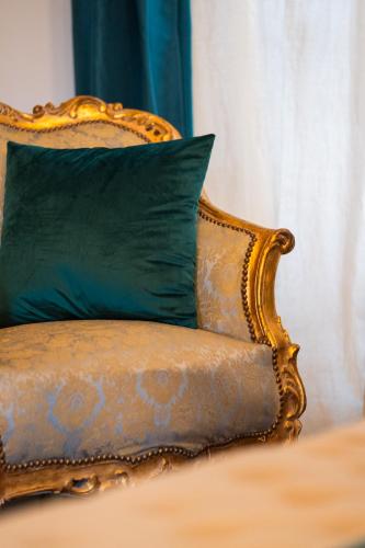 an old chair with a green pillow on a bed at Villa Hortensia in Bagnères-de-Bigorre