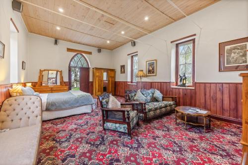 a bedroom with a bed and a couch and a table at Clare Valley Cabins in Clare