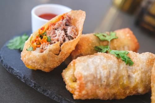 a plate with three food items with dipping sauce at BLU-Tique, Akron, a Tribute Portfolio Hotel in Akron