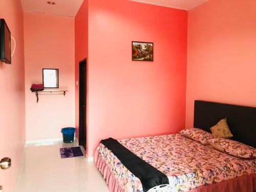 a bedroom with red walls and a bed in it at Chalet Sri Bayu in Kampong Balai Maras