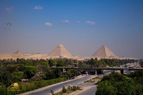 een uitzicht op de piramides van Giza vanuit een straat bij Pyramids sunrise inn in Caïro