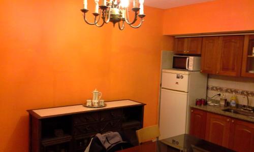 cocina con pared de color naranja y nevera en Residencia "Libertad " en San Andrés