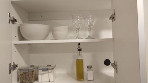 a kitchen cabinet with wine glasses and dishes on it at Vid_y_Olivo. Cómodo departamento en el centro de Maipú in Maipú