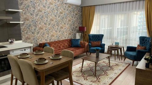 un soggiorno con divano, tavolo e sedie di شقة سياحية فندقية بمنطقة بشاك شهير بمجمع ميدكولية a Istanbul