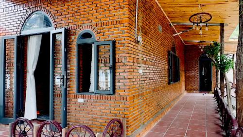 a brick building with two red bikes parked next to it at Da Let Homestay & Coffee in Hiệp Mỹ