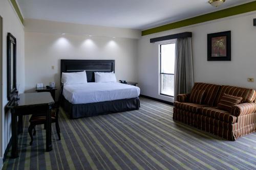 une chambre d'hôtel avec un lit et un canapé dans l'établissement Best Western Hotel Plaza Matamoros, à Matamoros