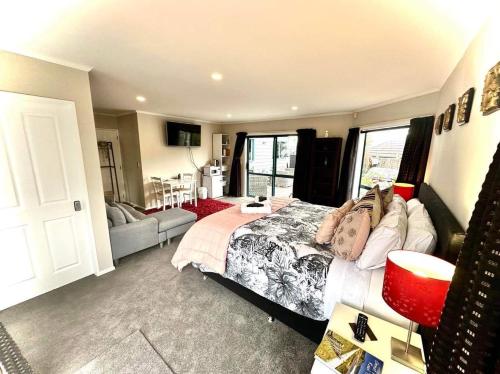 a bedroom with a bed and a living room at Observation Guest Suite in Paraparaumu