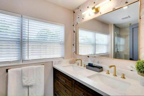 a bathroom with a sink and a large mirror at Lytle Palm Studio in West Palm Beach
