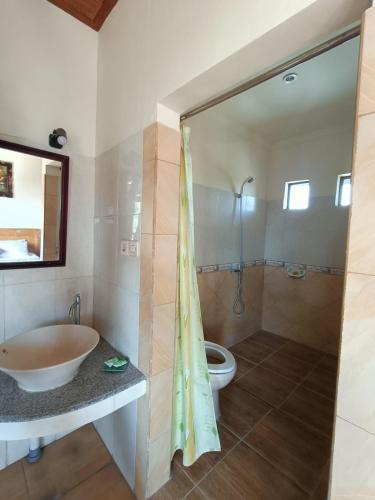 a bathroom with a tub and a sink and a toilet at Wahyu Accomodation in Ubud