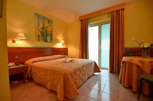 a hotel room with two beds and a window at Hotel Parco degli Ulivi in Scerne