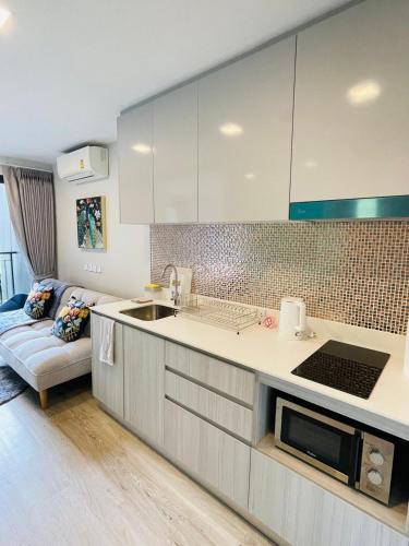 a kitchen with a sink and a couch in a room at Marvest Condo Hua Hin for rent in Hua Hin