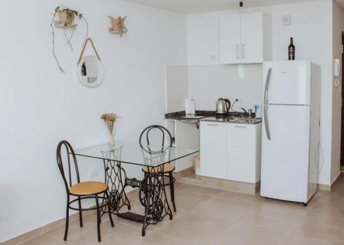 cocina con mesa, sillas y nevera en Yellow en San Miguel de Tucumán