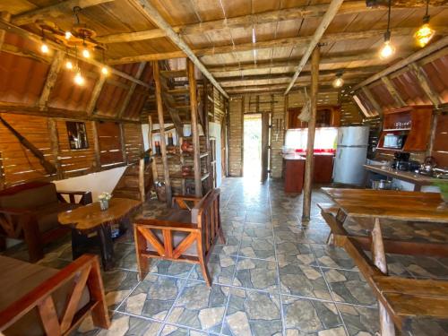 un restaurante con mesas de madera y sillas en una habitación en Cabaña El Viejo del Monte, en Venecia