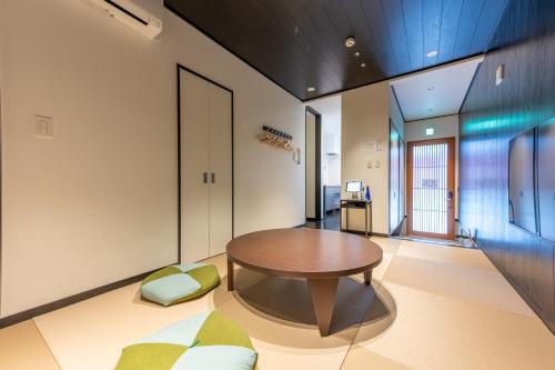 a living room with a wooden table and chairs at Irodori Hotel TOU in Fukuoka