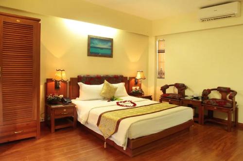a bedroom with a bed and two chairs and a table at Hoa Hồng 2 Hotel HN - by BAY LUXURY in Hanoi