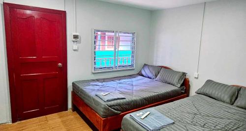 Zimmer mit Sofa, Bett und roter Tür in der Unterkunft Lucky Leprechaun in Koh Rong
